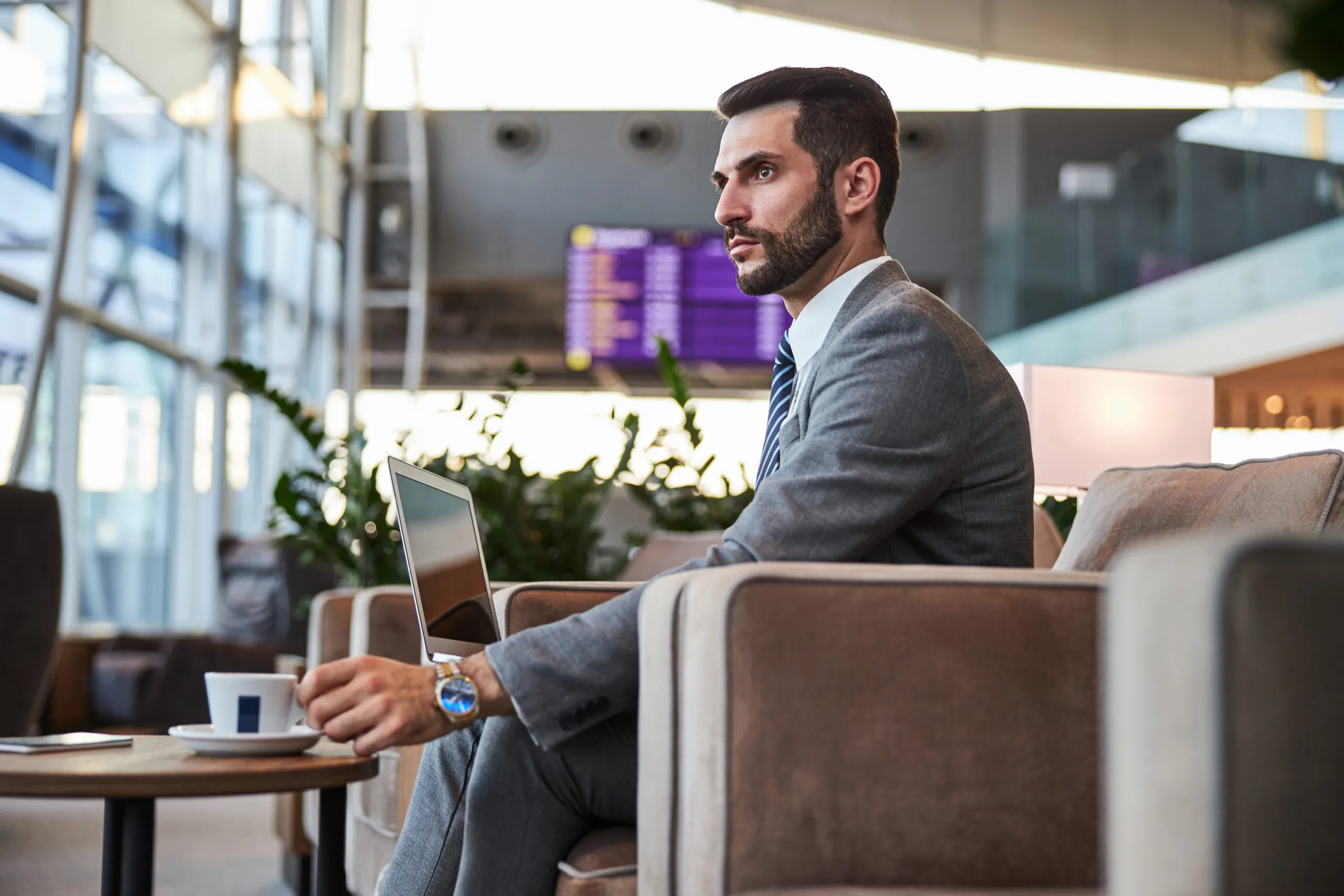 Traveler using a laptop in an airport lounge